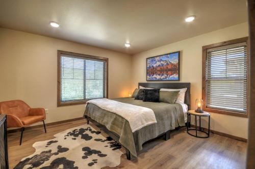 a bedroom with a bed and a chair and two windows at Basin Bungalow Red Lodge in Red Lodge