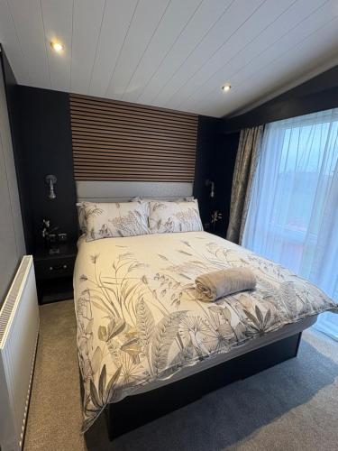 a bedroom with a large bed with a large window at The paddocks in Wisbech