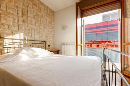 マラネッロにあるMaranello Suiteのベッドと大きな窓のある寝室