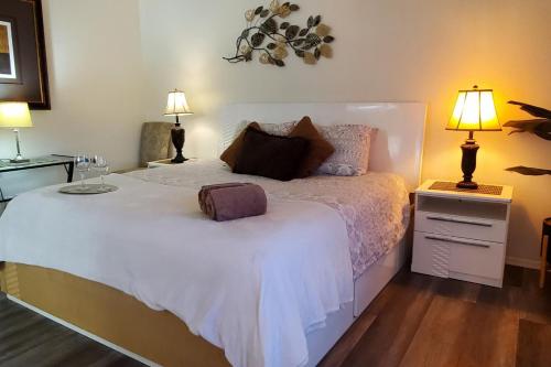 a bedroom with a large white bed with two lamps at Family Home with Hot Tub! 2 Mi to Dtwn Riverside in Rubidoux