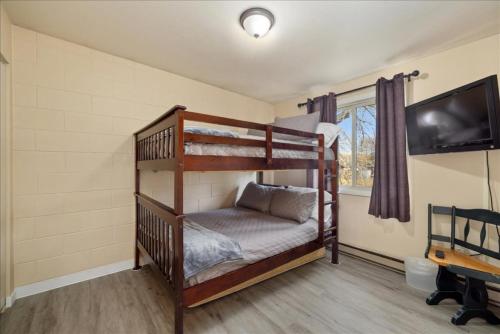 a bedroom with two bunk beds and a flat screen tv at Winchester Way Red Lodge in Red Lodge