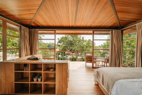 ein Schlafzimmer mit einem Bett und einem großen Fenster in der Unterkunft Villa Beruang in Uluwatu