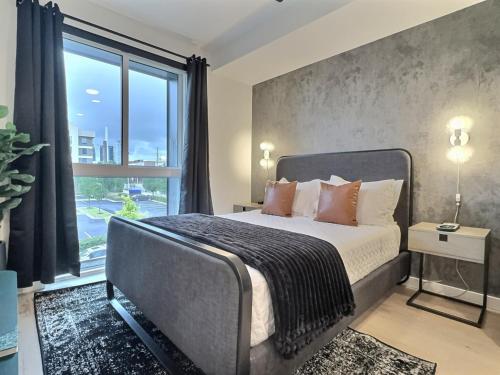 a bedroom with a bed and a large window at Modern Birmingham Retreat, Steps to Parks and Eats in Birmingham