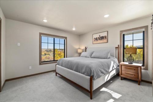 a bedroom with a large bed and two windows at Beartooth Mountain Lodge - Private hot tub - $50 dollar with 3 night stay in Red Lodge