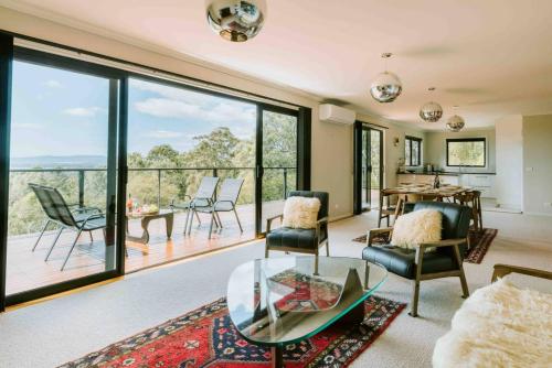 a living room with a glass table and chairs at Panorama Escape, Port Sorell in Port Sorell
