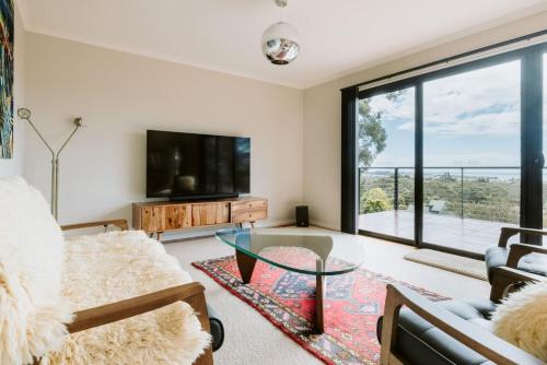 a living room with a glass coffee table and a large window at Panorama Escape, Port Sorell in Port Sorell