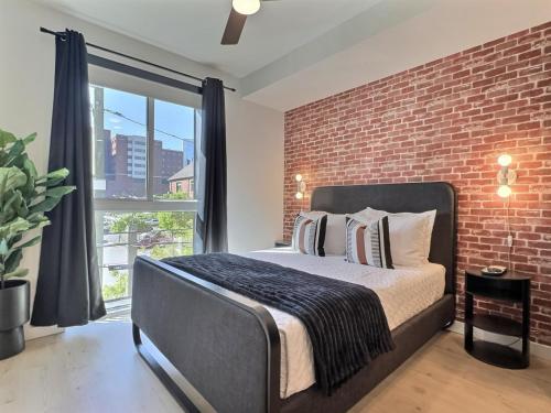 a bedroom with a brick wall and a bed at Relaxing City Stay, Walk to UAB and Local Dining in Birmingham