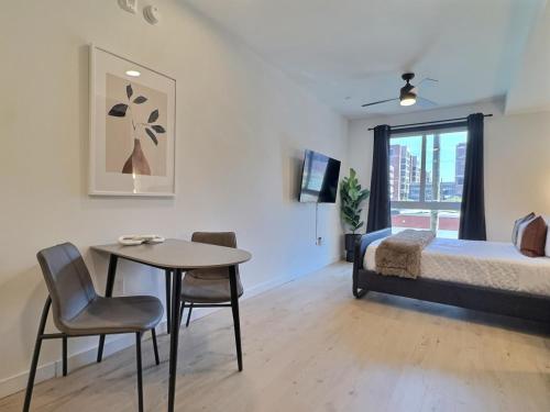 una camera da letto con un letto, un tavolo e delle sedie di Stylish Studio, Walk to Food, Bars and Baseball a Birmingham