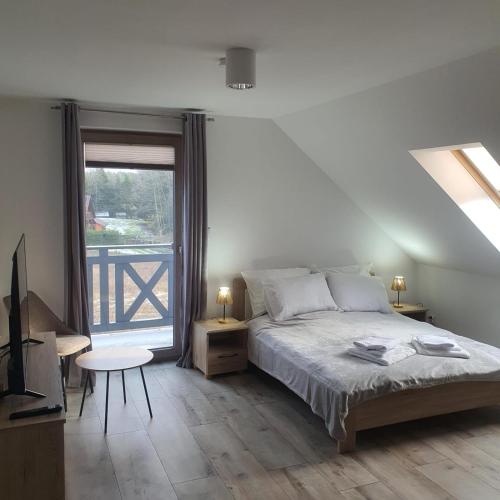 a bedroom with a bed and a large window at Wypoczynek KOPANICA in Kopanica