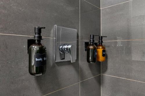 dos botellas de jabón en una pared en un baño en Flat at the Foot of the Mountain With Parking, en Montreal