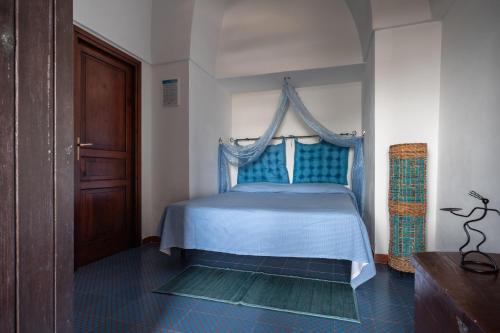 een slaapkamer met een blauw bed en een baldakijn bij Appartamento Esperanza blu in Scauri