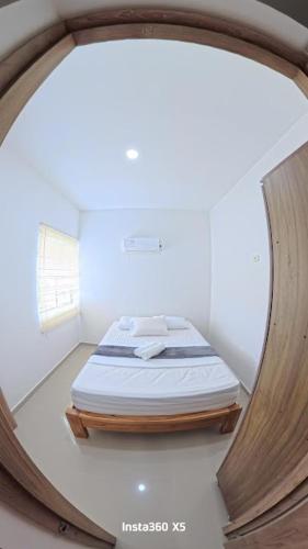 a bed in a room with a round mirror at Amanecer Caribe 4503 in Coveñas