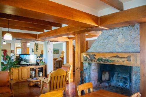 a living room with a large stone fireplace at Hosteria y Cabañas Posada Quinen in San Martín de los Andes