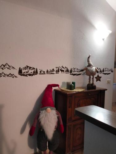 Eine Weihnachtsmannfigur sitzt auf einer Theke in einem Zimmer. in der Unterkunft La petite étoile in Aosta
