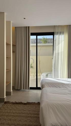 منتجع أحجار لبيوت العطلات في الطائف: غرفة نوم بها سريرين ونافذة كبيرة