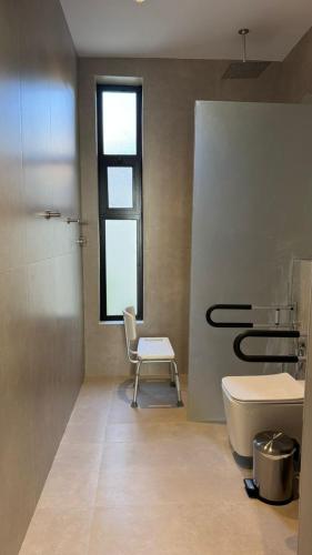 منتجع أحجار لبيوت العطلات في الطائف: حمام مع مرحاض ومغسلة وكرسي