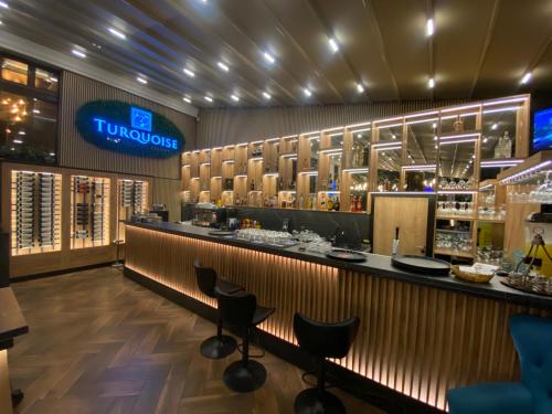 eine Bar in einem Restaurant mit Hockern in der Unterkunft TURQUOISE Hostel in Bukarest