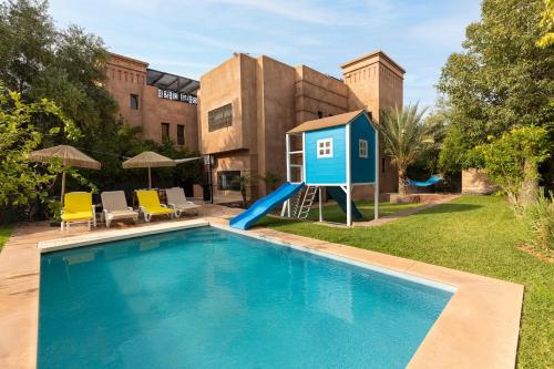 una casa con piscina con una casa de juegos azul en Villa Riad Private heated Pool with breakfast, en Marrakech