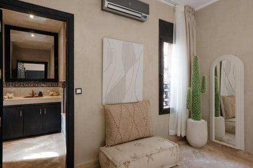 Un baño con una silla, un lavabo y un espejo. en Villa Riad Private heated Pool with breakfast, en Marrakech
