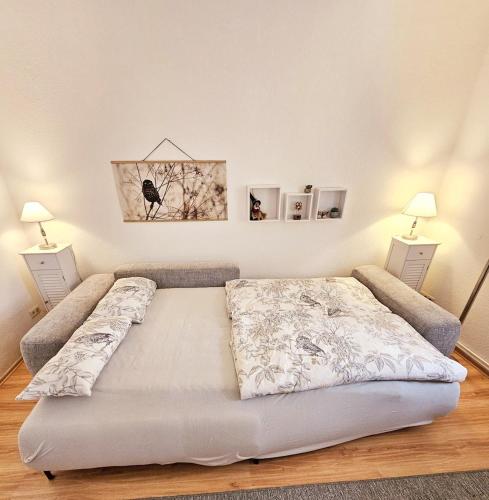 a large bed in a room with two lamps at Ferienwohnung Harzgefühl in Elbingerode