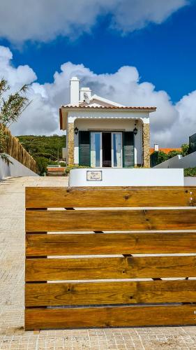a wooden fence in front of a house at Villa over the Ocean in Magoito-Sintra in Sintra