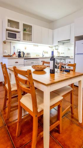 a kitchen with a wooden table with a bottle of wine at Villa over the Ocean in Magoito-Sintra in Sintra