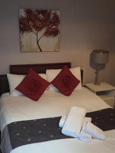 a bedroom with a bed with red and white pillows at Kings Head Hotel in Kirkbymoorside