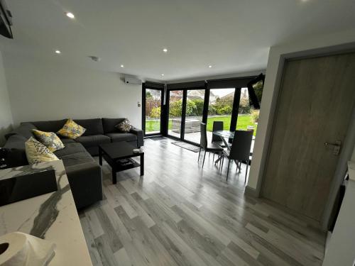 a living room with a couch and a table at Whispering Waves Guest house, Brighton-8 mins, Guests 4, Beachfront, Free parking, WiFi, Kitchen and AC in Peacehaven