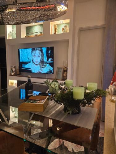 sala de estar con mesa y TV en la pared en Harz High End Fewo Nicholas 4 Sterne DTV, en Goslar