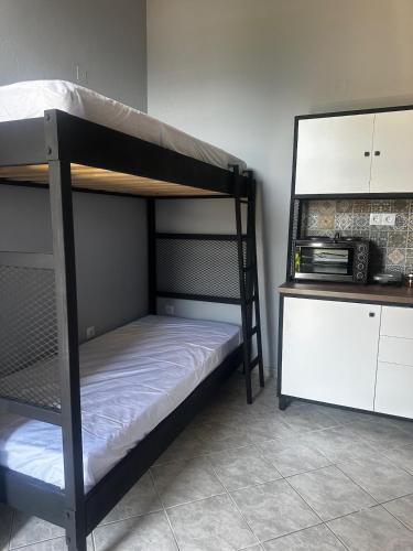 two bunk beds in a room with a microwave at Letsios Steel2 in Kalabaka