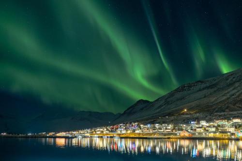 ein Bild einer Stadt mit der Aurora im Himmel in der Unterkunft Landakot The Perfect Getaway by StayNorth in Siglufjörður