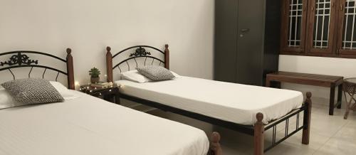 two beds in a room with two tables at The Bro's code in Puducherry