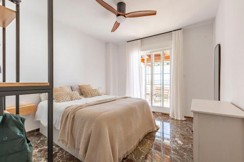 una camera da letto con un letto e un ventilatore a soffitto di Miramar a Castell de Ferro