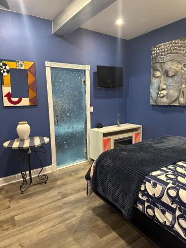 a bedroom with a bed and a television on a wall at 420 Suites & Blue Spa Bath in Washington, D.C.