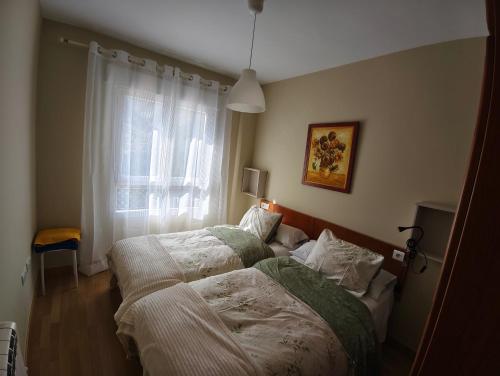 una camera da letto con due letti e una finestra di Mirador del Duque a Güéjar-Sierra