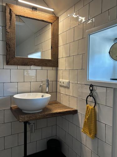 a bathroom with a white sink and a mirror at De Emmahoeve in Holthone