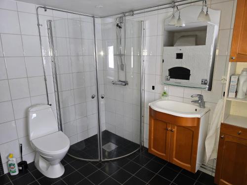 a bathroom with a shower and a toilet and a sink at Kringelgården in Stamsmåla