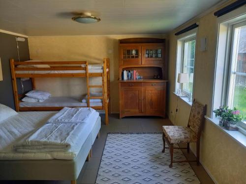 a bedroom with two bunk beds and a chair at Kringelgården in Stamsmåla
