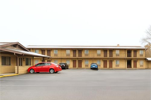 ein rotes Auto, das vor einem Gebäude geparkt ist in der Unterkunft Canton Inn By OYO in Canton