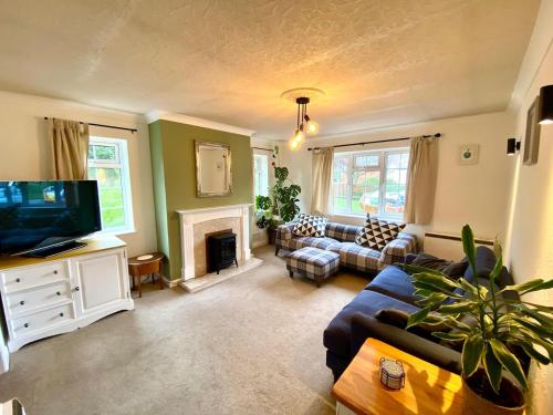 a living room with a couch and a tv at Tranquil Countryside Cottage near Loughborough
