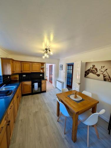 a large kitchen with a wooden table and chairs at Tranquil Countryside Cottage near Loughborough