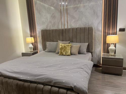 una camera da letto con un letto grande con due lampade di Executive 1-Bed Luxury Apartment with City View ! Zeta Mall Islamabad a Islamabad