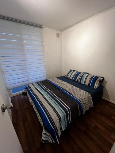 a bedroom with a bed and a window with a blind at Beautiful Portal Santo Domingo Apartment in San Antonio