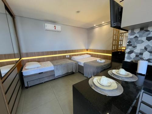 a hotel room with two beds and a table at Haven Residence in Uberlândia