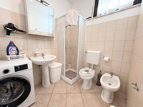 un bagno con un lavandino del water e una lavatrice di Appartamento la casa di Lilli Anguillara Sabazia-Lago, Relax e Roma a portata di treno a Anguillara Sabazia