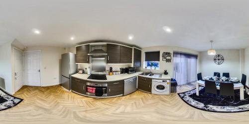a large kitchen with wooden floors and stainless steel appliances at Sunderland Haven: Modern 4-Bedroom Family Retreat in Sunderland