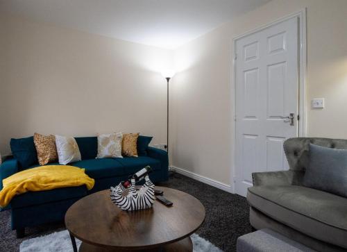 a living room with a blue couch and a table at Sunderland Haven: Modern 4-Bedroom Family Retreat in Sunderland