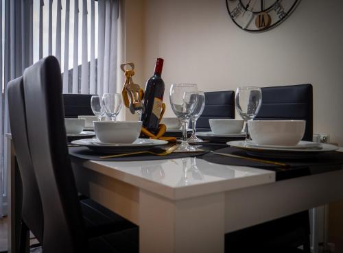 a dining table with glasses and a bottle of wine at Sunderland Haven: Modern 4-Bedroom Family Retreat in Sunderland