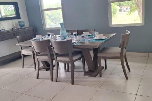 a dining room table with chairs and a wooden table with at Casa Bellavista - 2BR Beachview Villa by Veritas Pacifica in San Diego