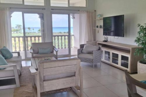 a living room with a television and a couch and chairs at Casa Bellavista - 2BR Beachview Villa by Veritas Pacifica in San Diego